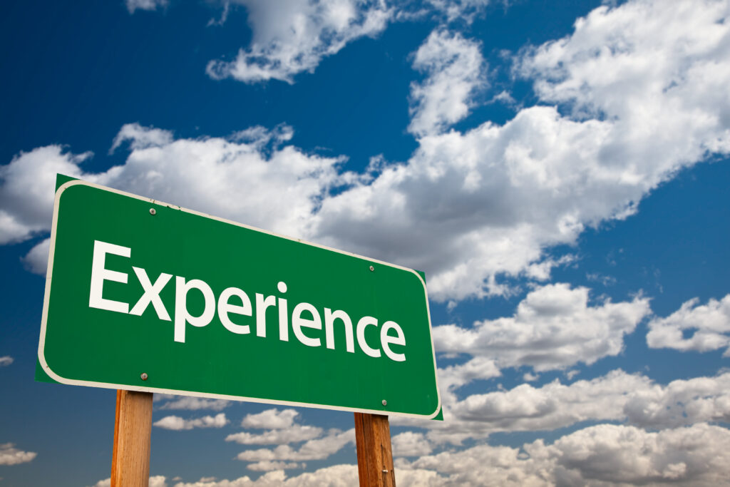 Straßenschild vor blauem Himmel mit dem Wort "Experience"