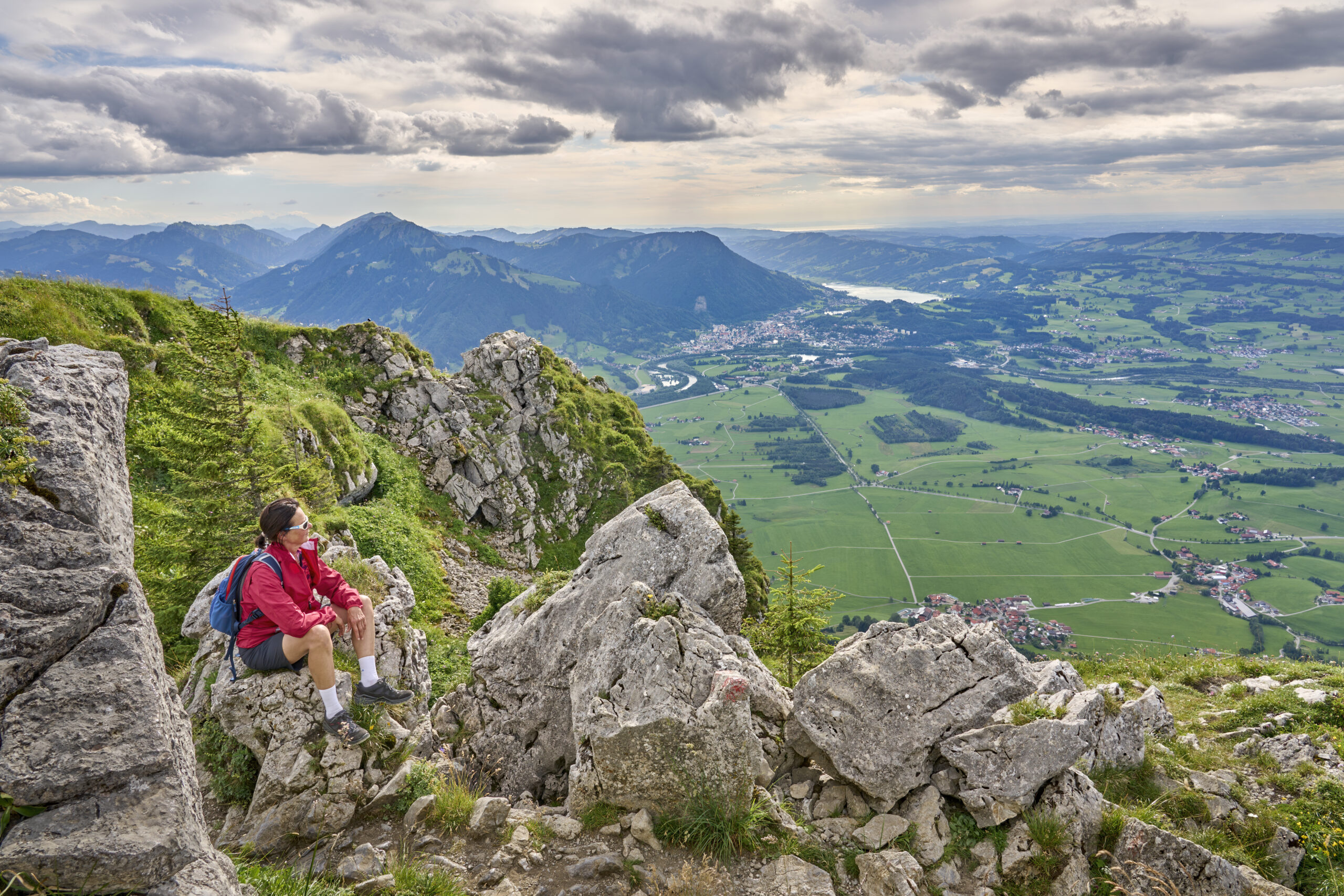 Wanderin auf Bergspitze mit Talblick