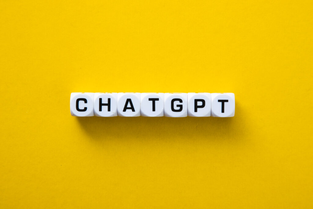 Weiße Würfel vor gelben Hintergrund bilden Wort "ChatGPT"