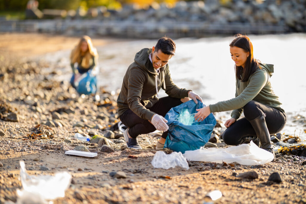 Personan sammeln Plastikmüll am Strand auf