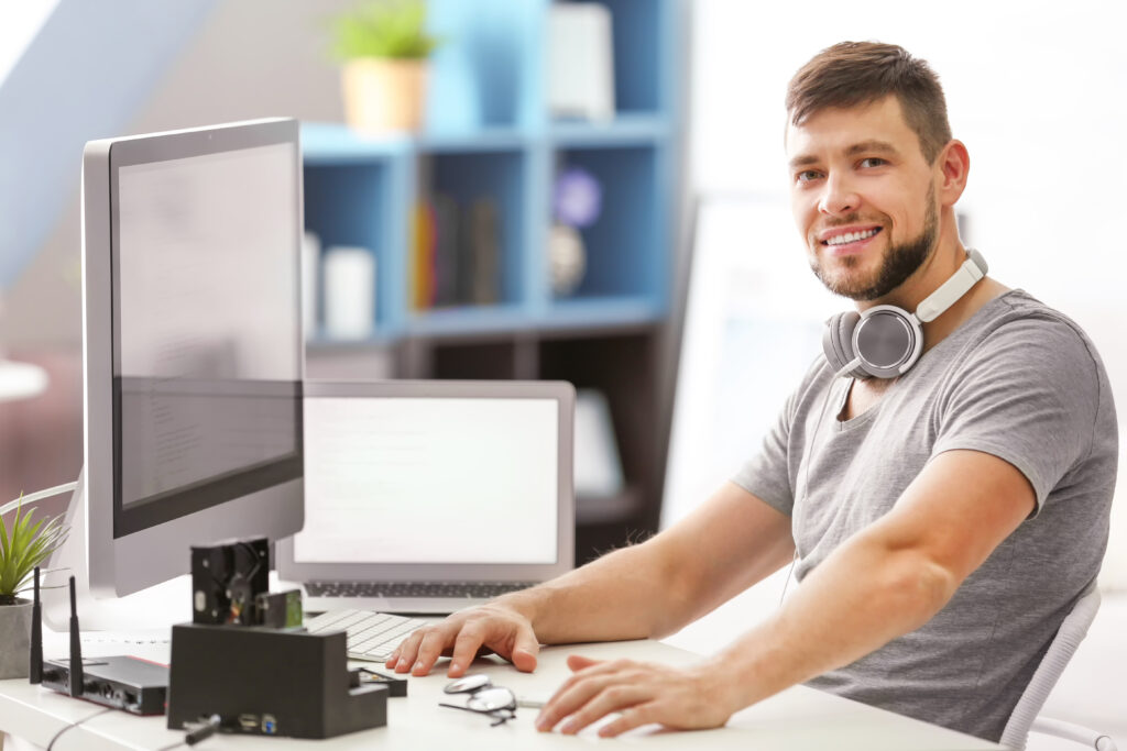 Junger Mann bei der Arbeit am PC im Büro