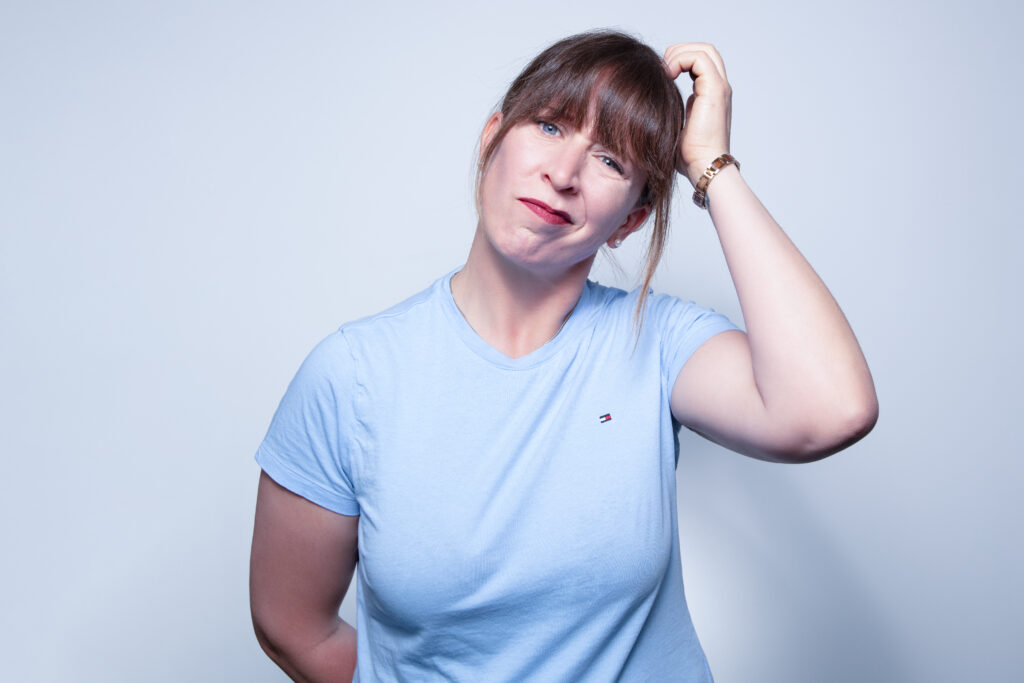 Bild von Nina Kirsch, die sich grübelnd mit der Hand an den Kopf fässt.