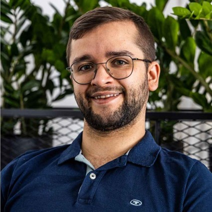 Bild von Georg Drescher, dem Gründer von Bloxxi, der eine Brille trägt und ein blaues Poloshirt. Er hat braune Haare und lächelt freundlich.