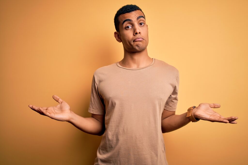 Bild eines jungen Mannes, der die Schultern zuckt und Arme in einer "ich weiß es nicht" Geste von sich hält.